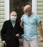 male-nurse-senior-woman-with-cane-nursing-home