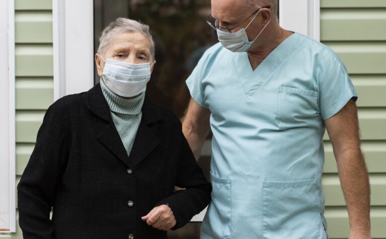 male-nurse-senior-woman-with-cane-nursing-home