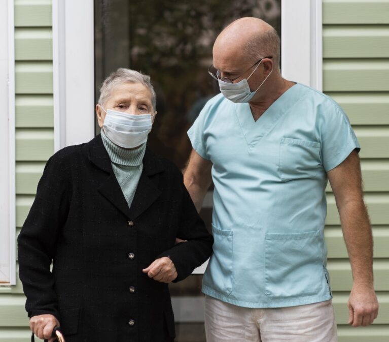 male-nurse-senior-woman-with-cane-nursing-home